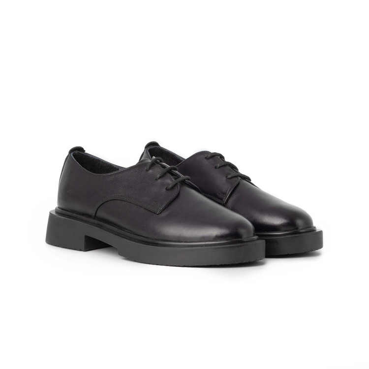 نمای جانبی کفش دربی زنانه مشکی چرم طبیعی با طراحی ساده و زیره لژدار PU.